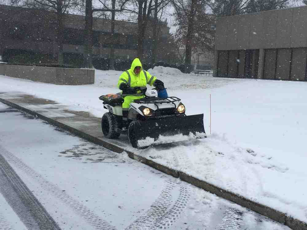 large complex commercial parking lot being plowed - cost of snow removal services