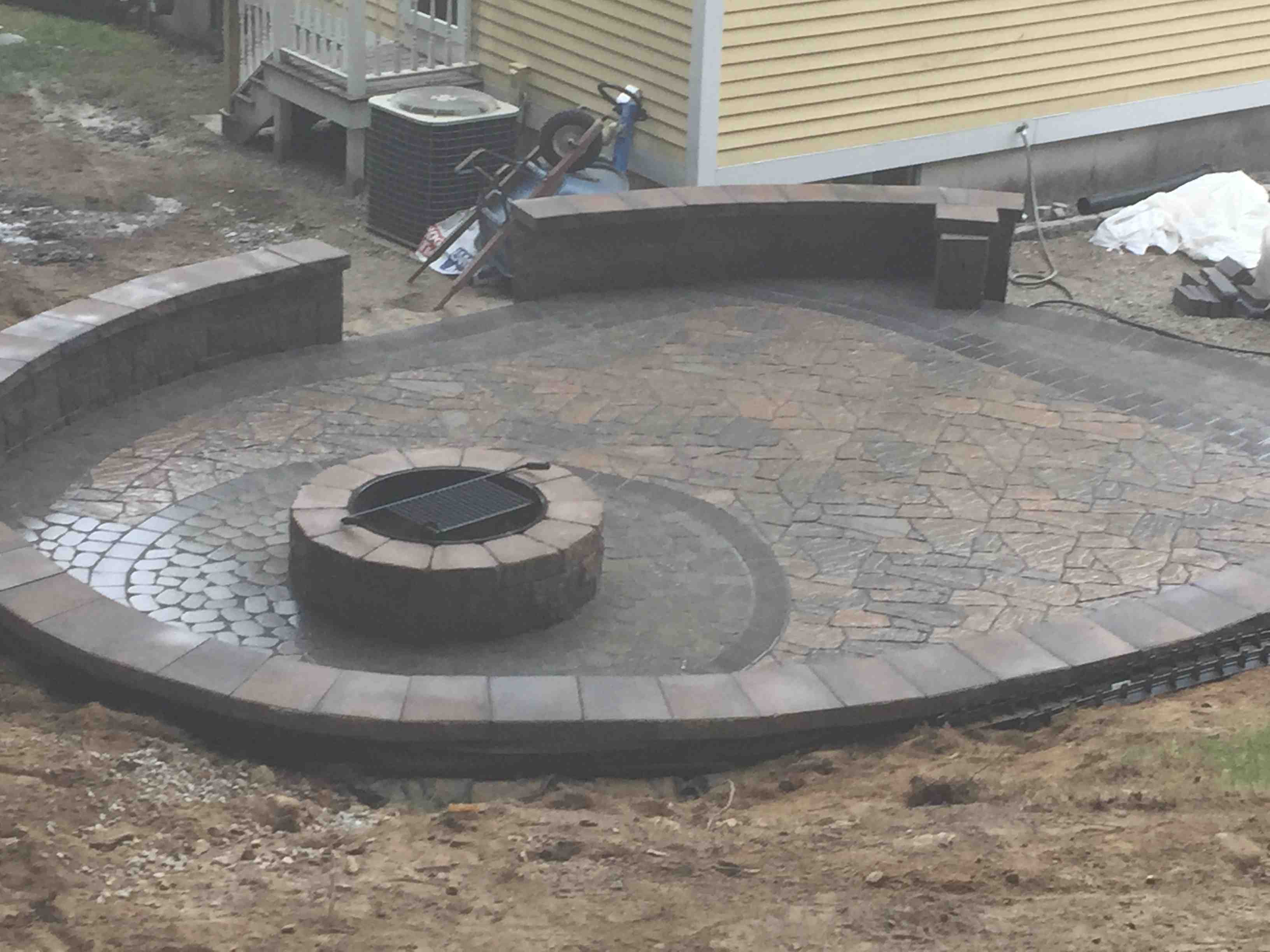 paver patio with a built-in fire pit and seat wall - paver patio cost installed